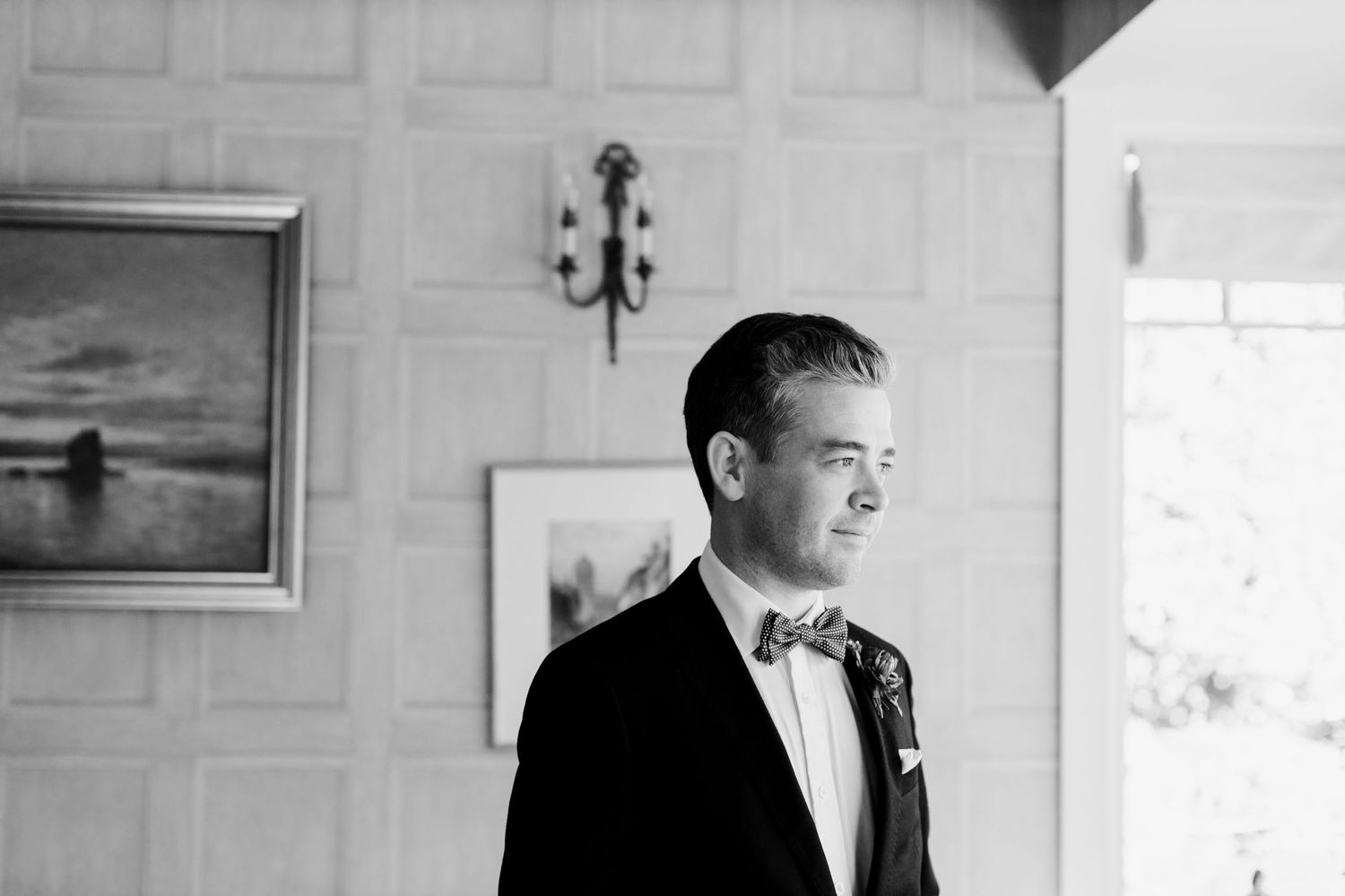 A classic black and white portrait of a groom in a bow tie and tuxedo.