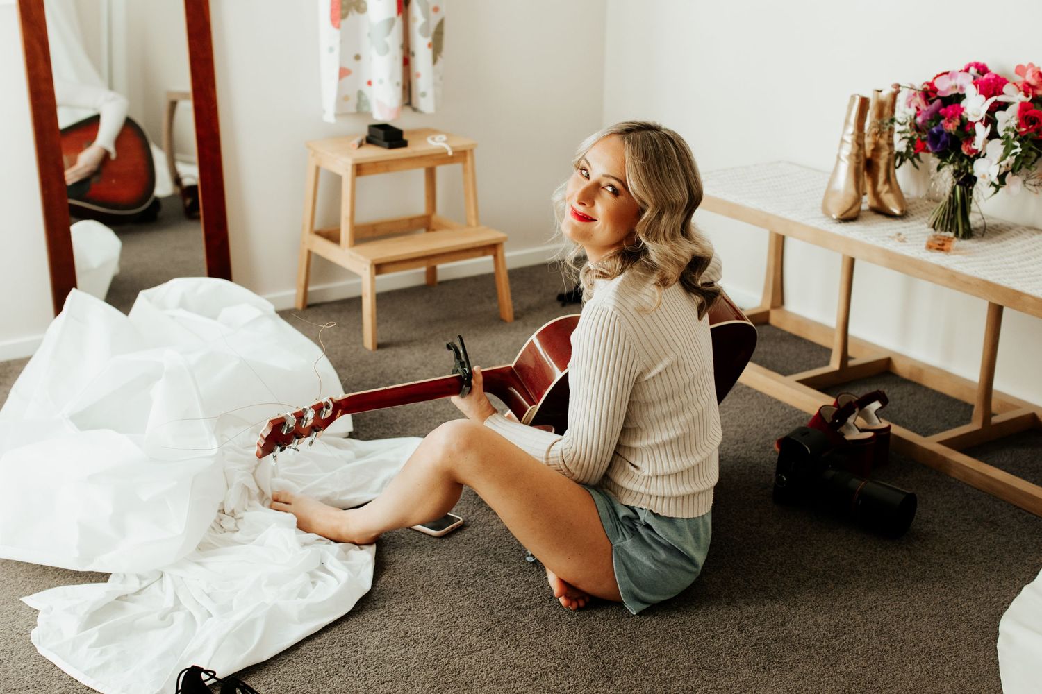 Wedding preparation scene showing dress and decor in natural light setting.
