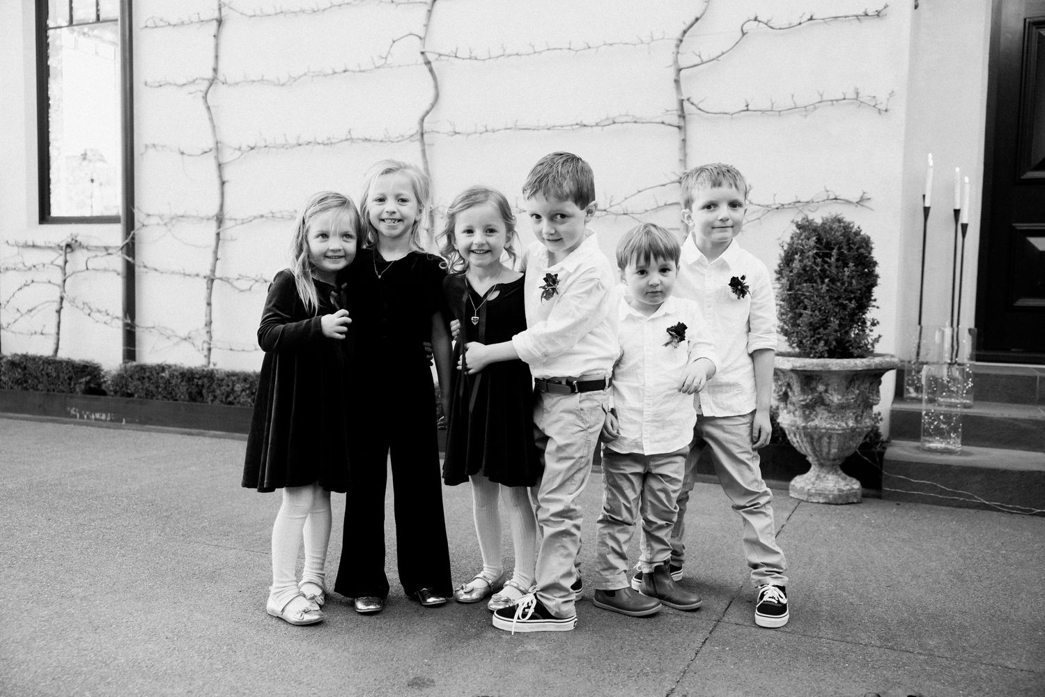 Black and white photo of children standing together outside.