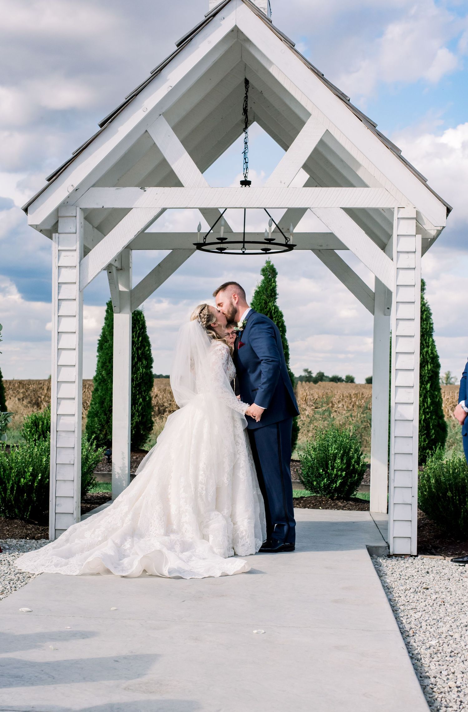 Wedding couple sharing an intimate moment under a white garden gazebo. Indianapolis, Indiana. Angela Hartwig Photography.