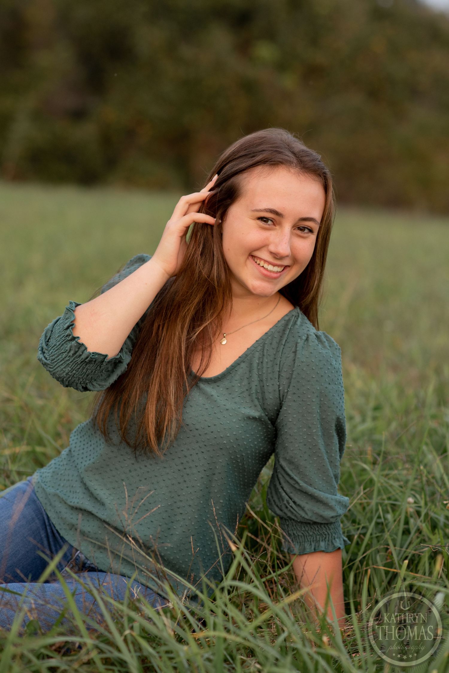 Natural outdoor portrait session in a green field with soft evening lighting.