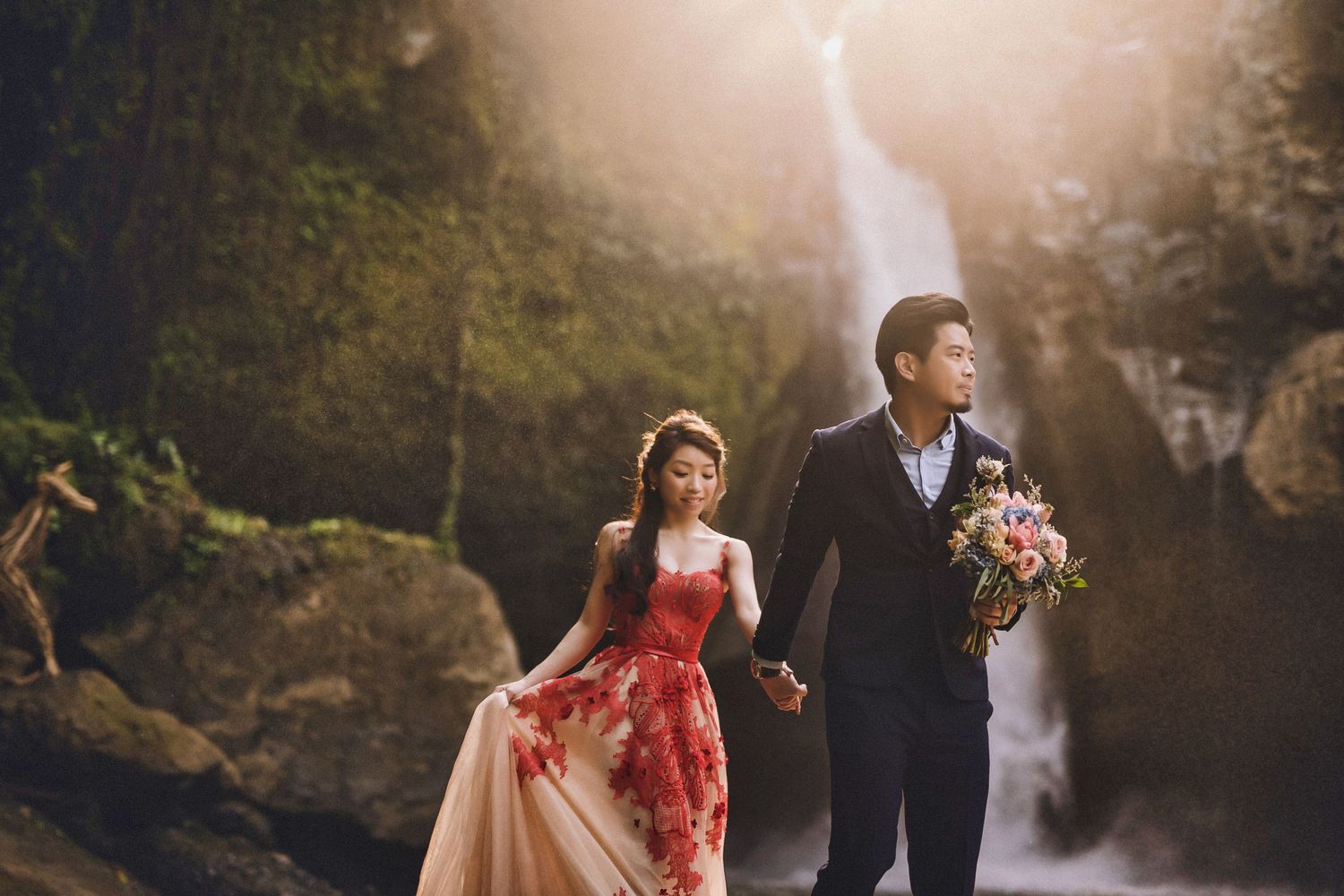 Romantic couple shares tender moment by dramatic waterfall.