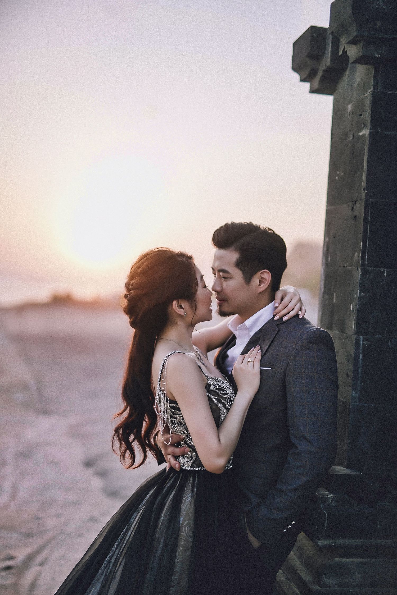 Romantic moment captured at sunset near ornate temple architecture.