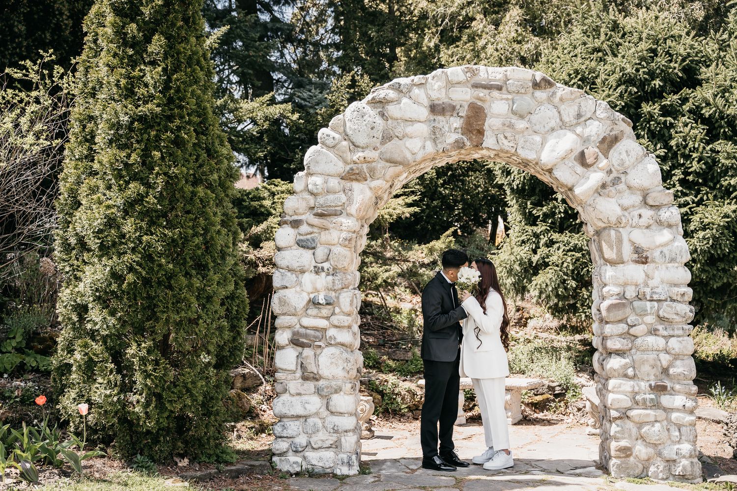 Groom and Bride kissing beneath an arch