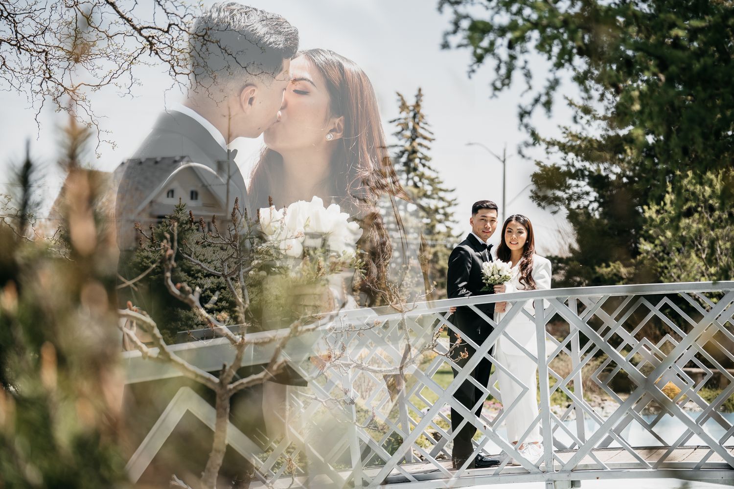 Groom and Bride kissing and looking towards the camera standing on a bridge
