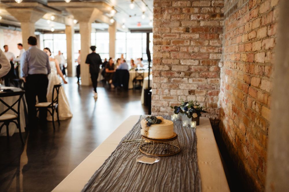 Industrial wedding venue interior with exposed brick walls and wooden tables.