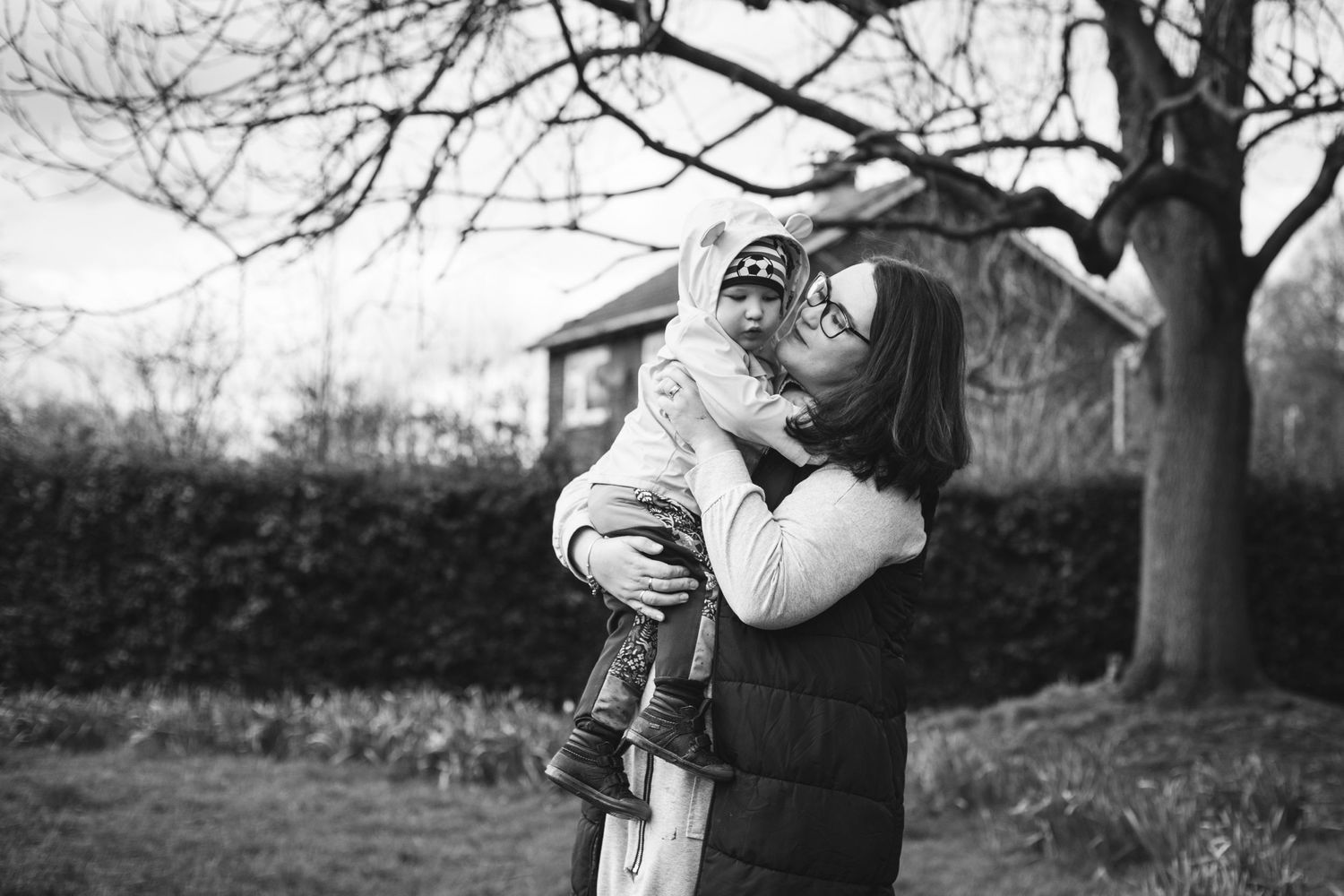 Tender embrace shared outdoors on a cloudy day.