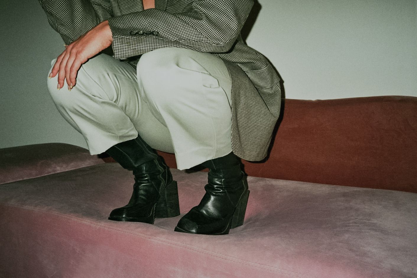 35mm film fashion portrait of woman in her home dressed in slacks and black boots