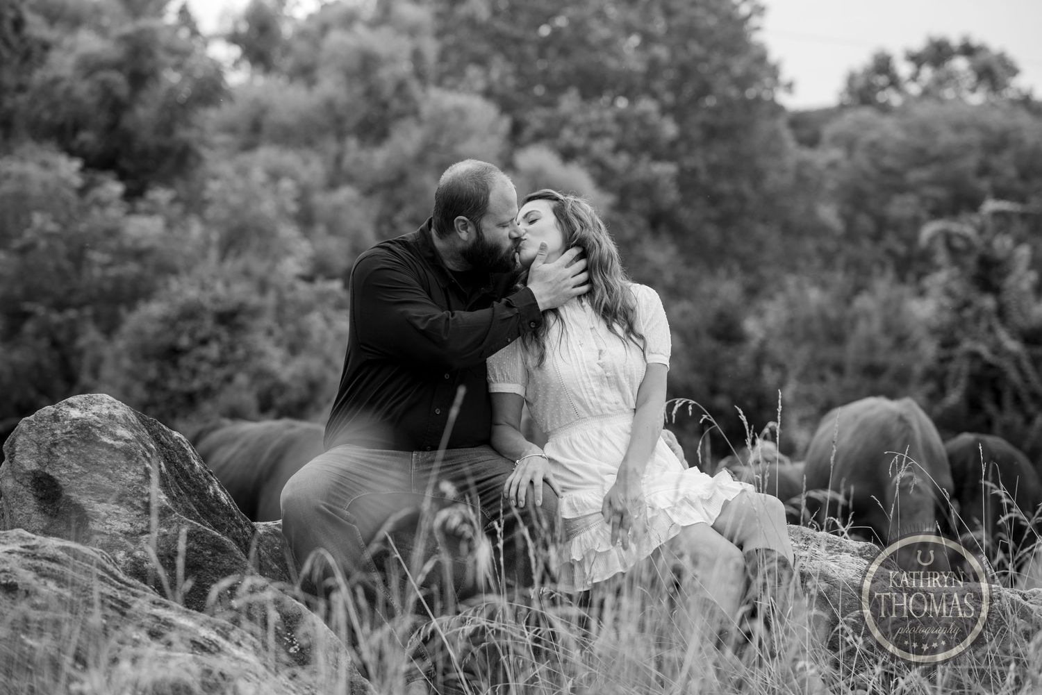 Romantic couple sharing an intimate moment while sitting in tall grass.