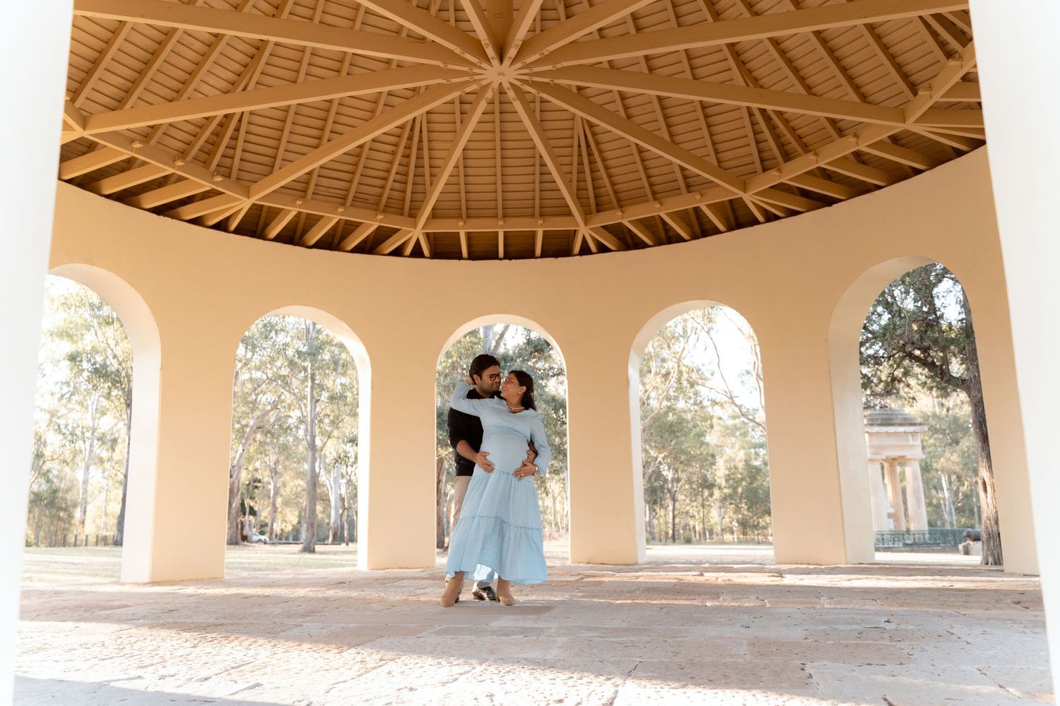 Dancing in the parramatta park rotunda during maternity photoshoot