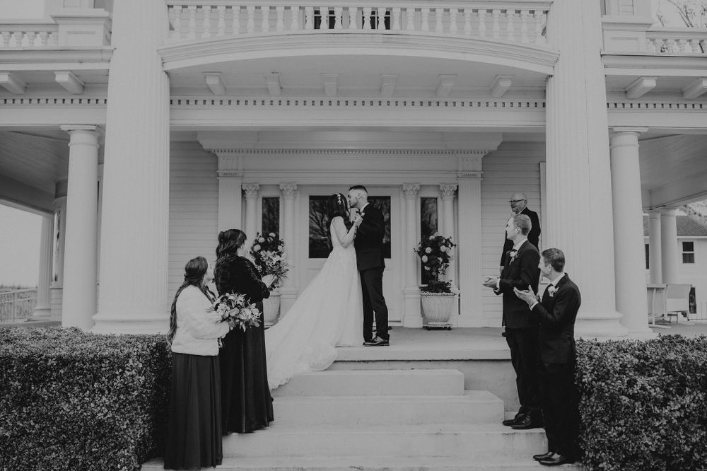 First kiss as bride and groom on the front steps of the mansion.