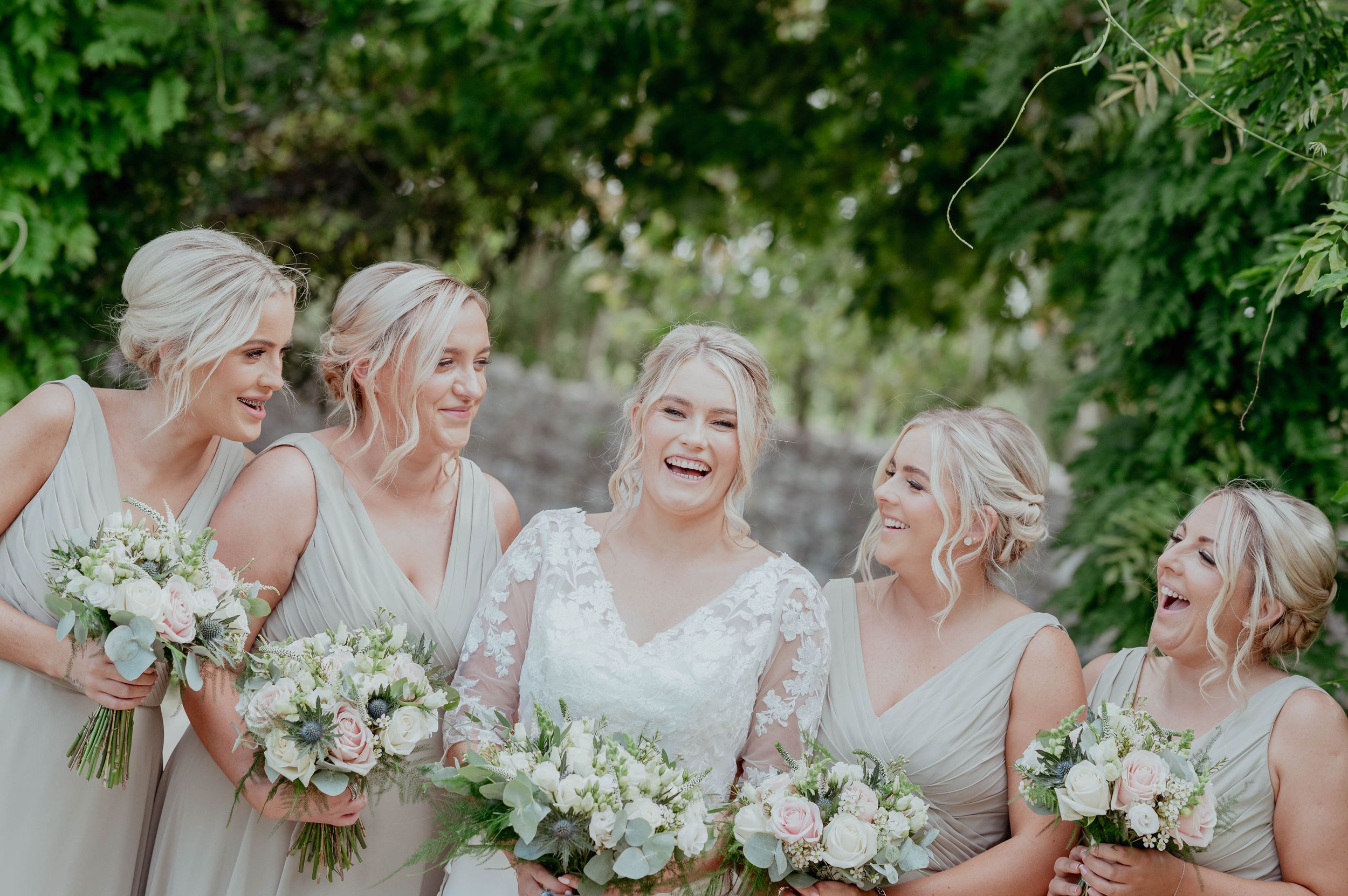 Bridal party laughing and looking at the bride