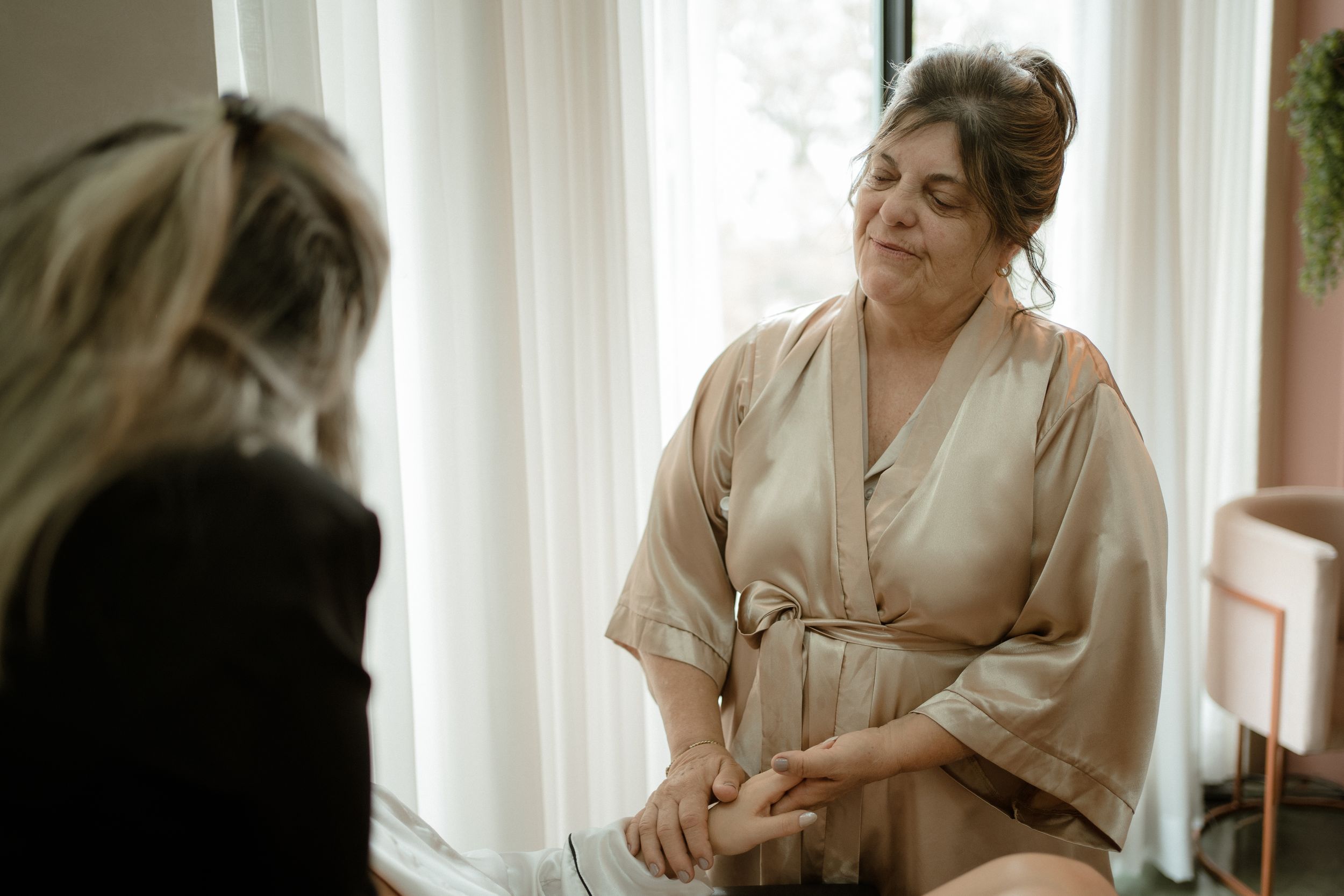 Getting ready scenes in robes during morning wedding preparations by window light.
