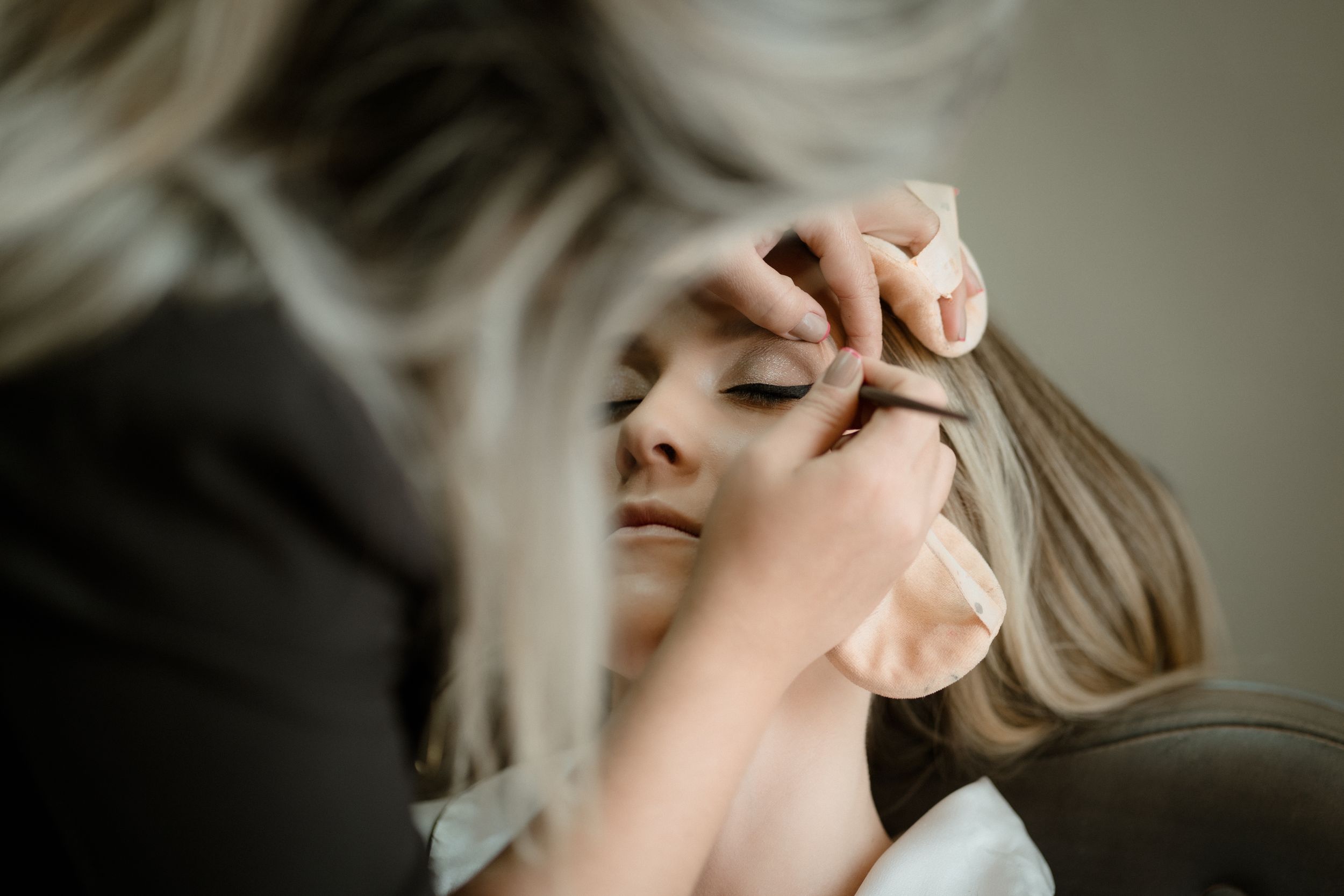 Close-up shot of someone having makeup applied to their eyes.