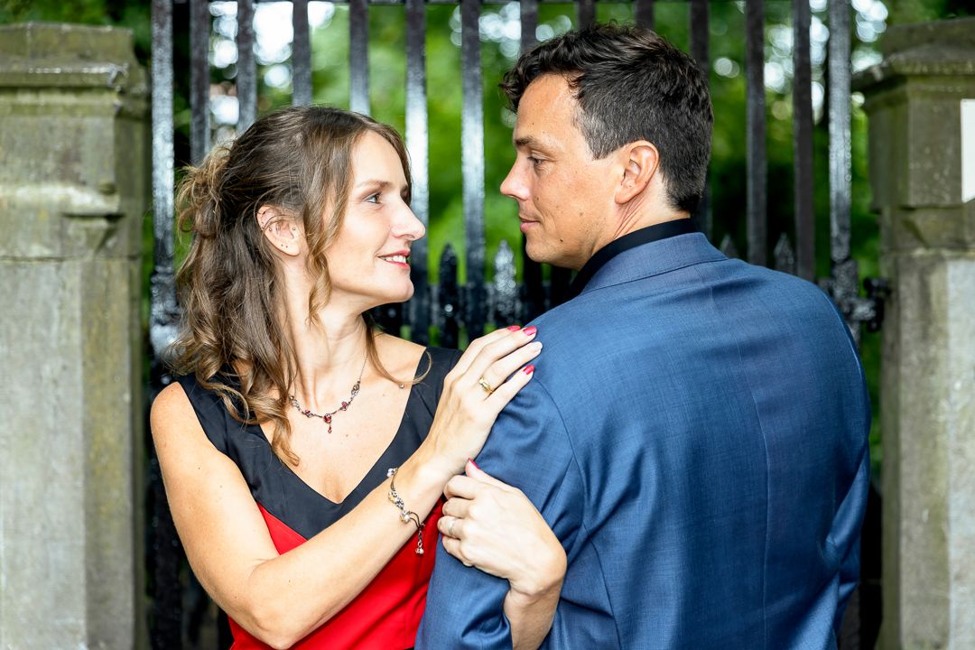 A romantic outdoor engagement portrait near ornate iron gates.
