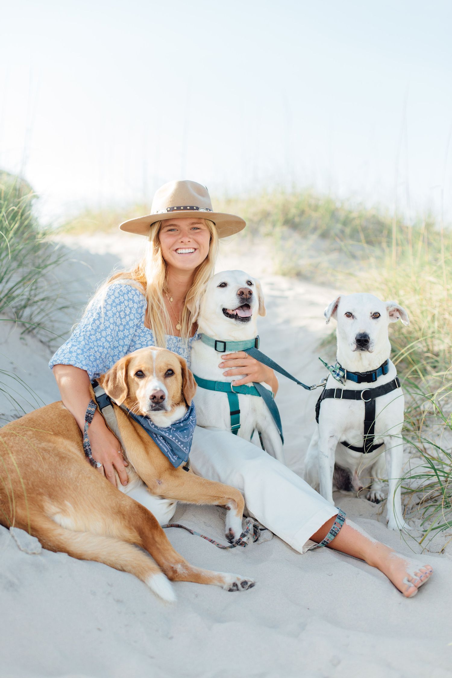 Janie sitting with her three dogs at the beach