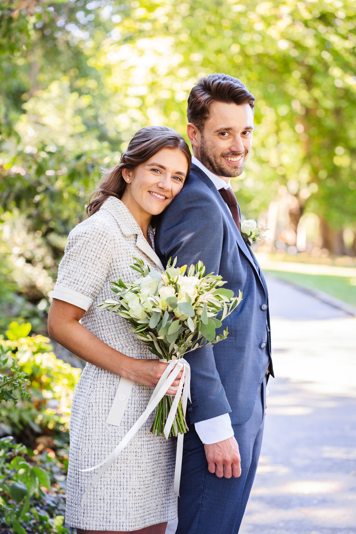 married couple looking at the camera, bride holding the bouquet