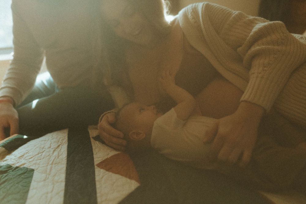 An intimate moment captured on a patterned quilt in warm vintage tones.