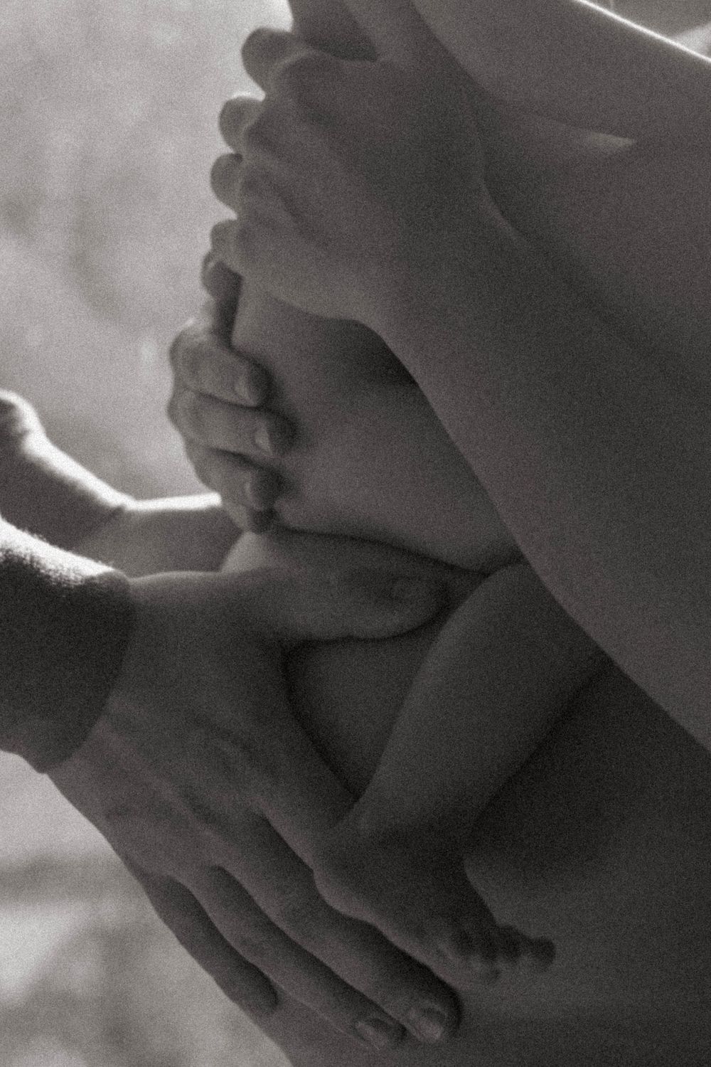 Close-up black and white photo of hands tenderly touching.