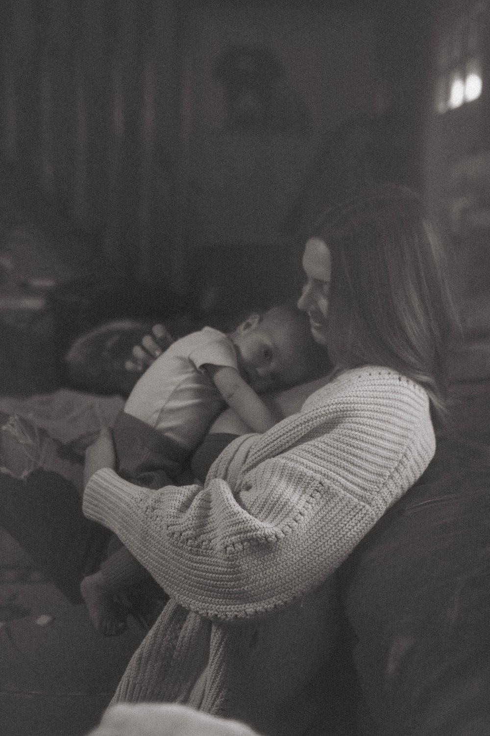A quiet monochrome moment of comfort and connection on a dark leather sofa.