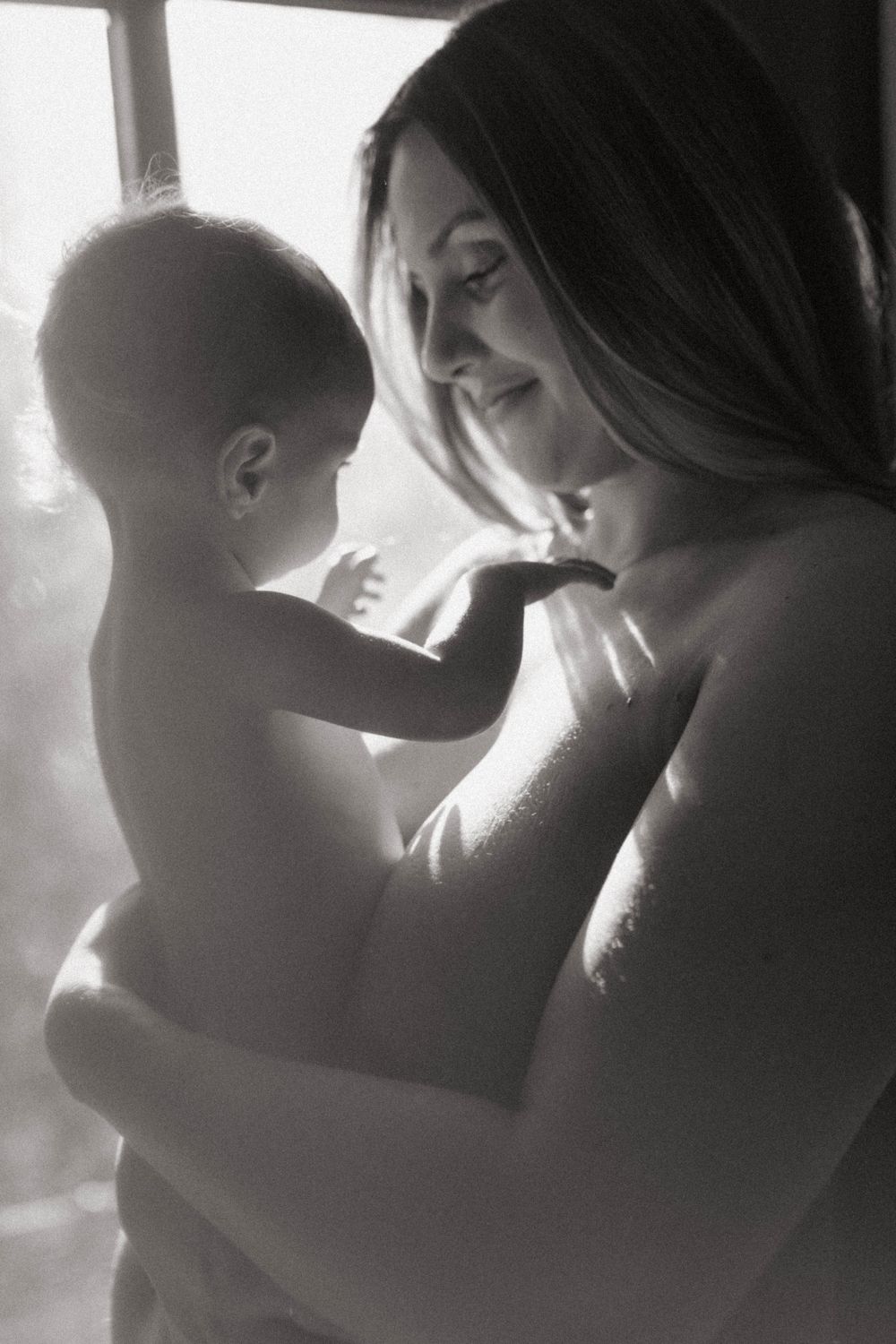 A black and white portrait capturing a tender moment between parent and child.