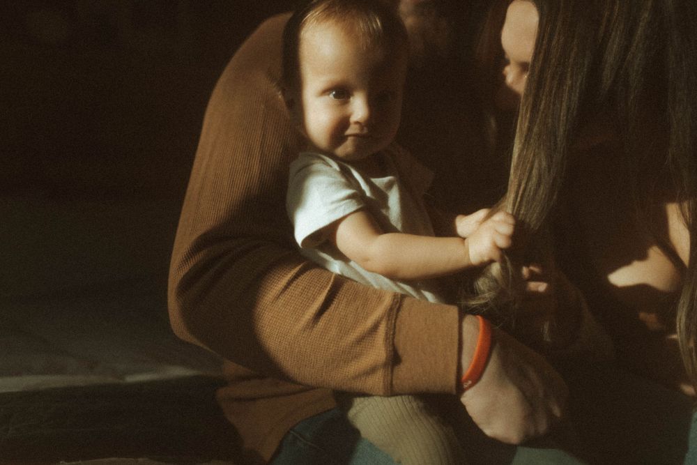 Small child held in arms with vintage sepia toning.