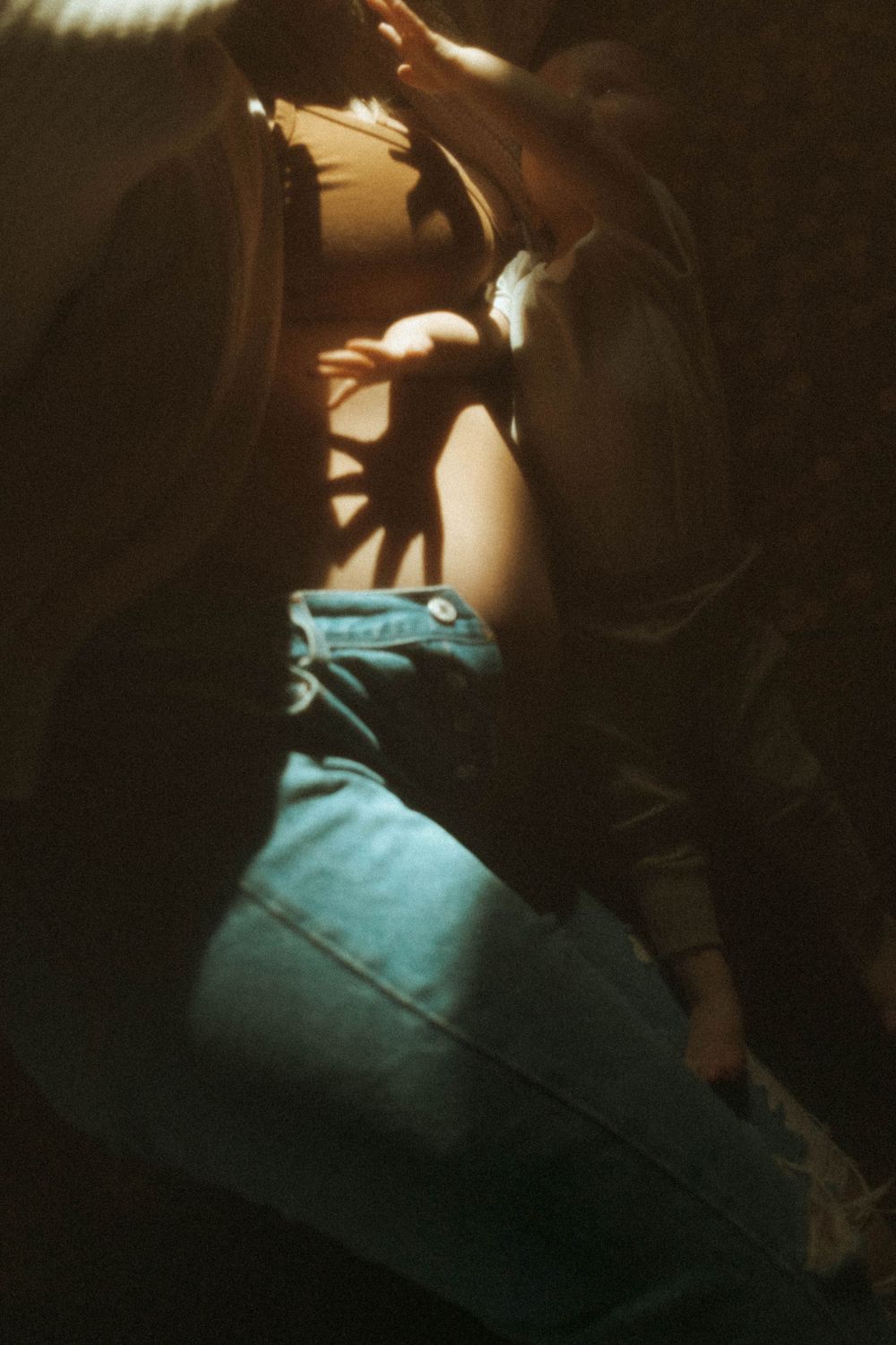 Artistic close-up photograph with dramatic lighting and denim textures.