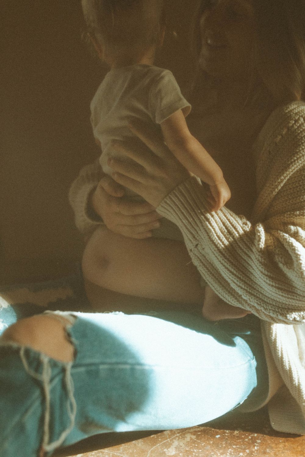 Artistic low angle shot showing intimate family bonding moment in warm lighting.