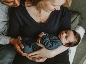 Heartfelt newborn photography in Sydney & Northern Beaches, showing mom and dad gazing lovingly at their sleeping baby, celebrating family l
