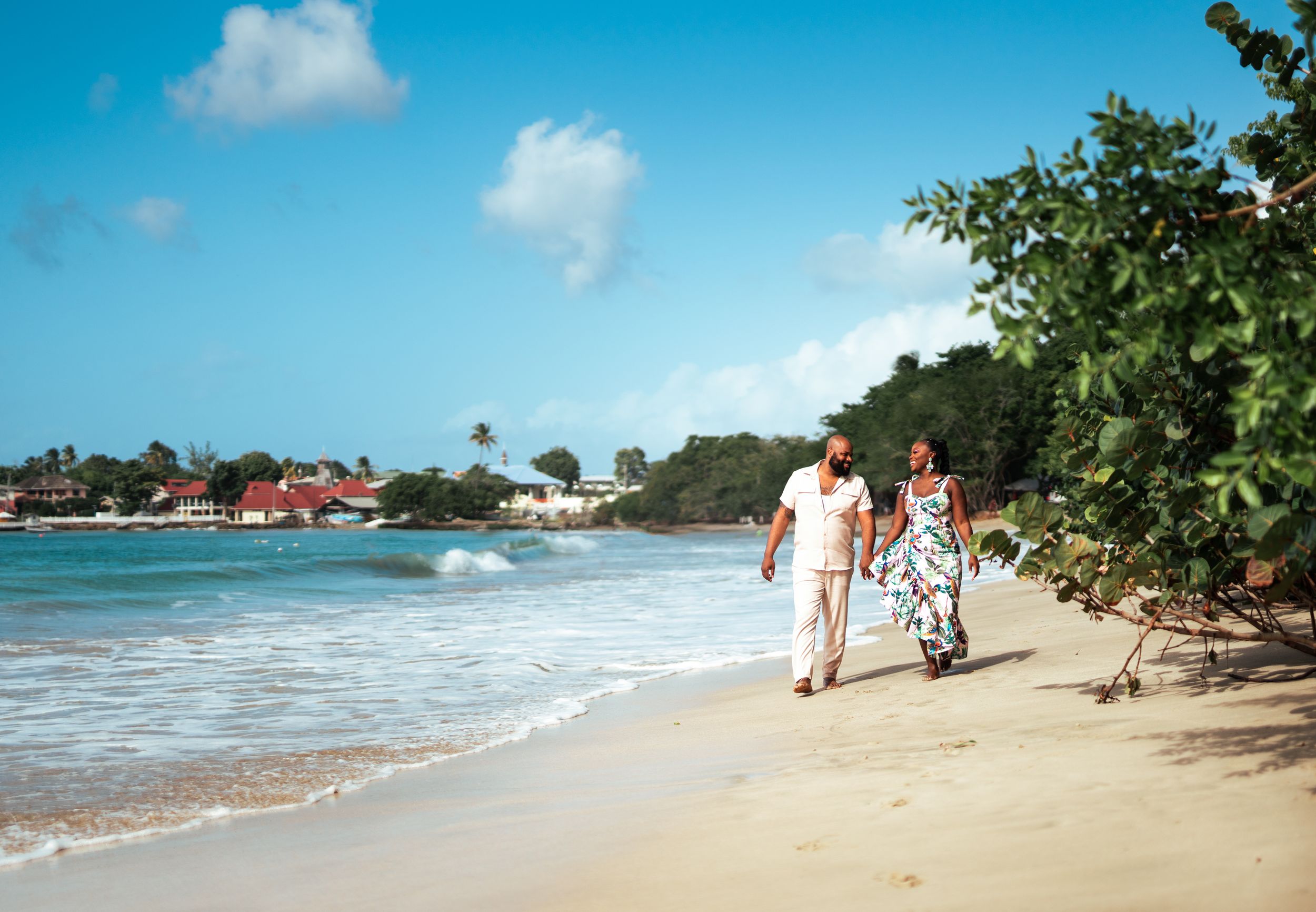 Scenic beach walk with couple strolling along tropical shoreline.