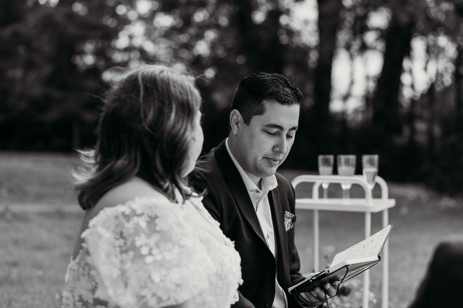 Black and white photo of a couple during an intimate outdoor wedding ceremony.