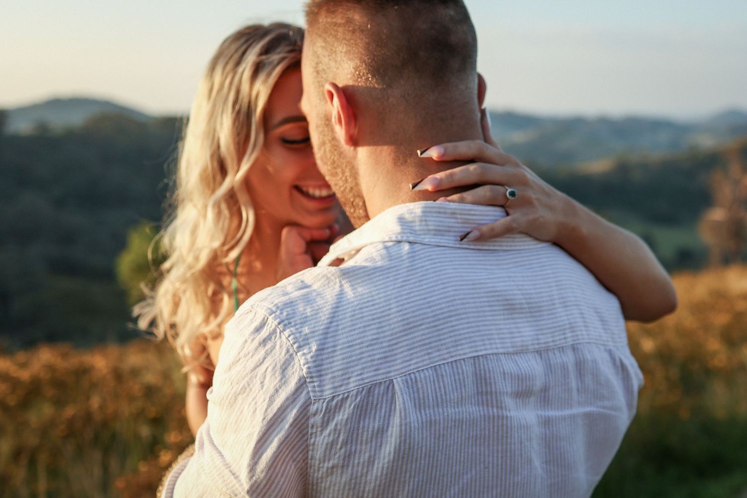 An intimate moment captured between a couple during golden hour in nature.