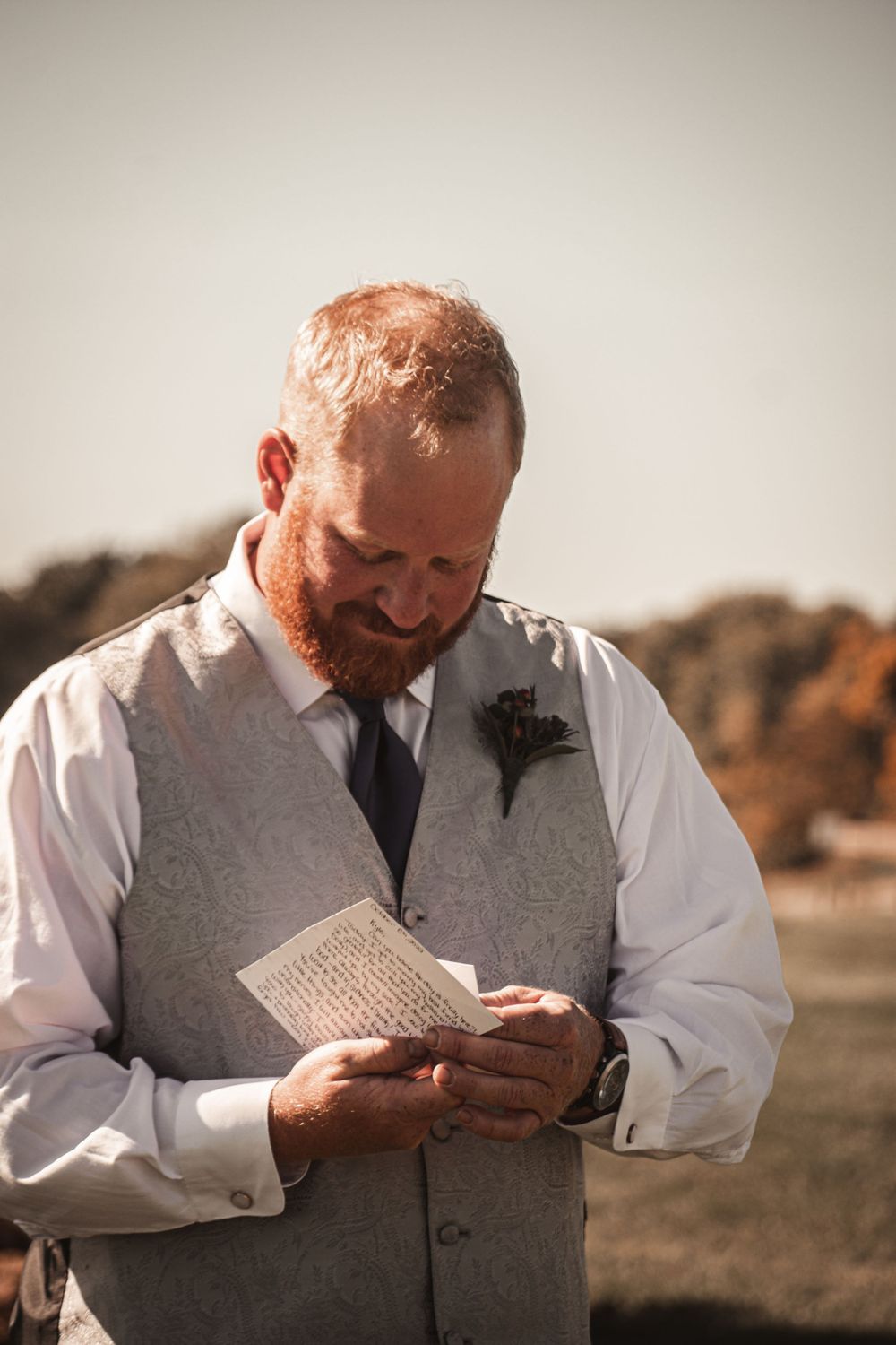 Close-up emotional moment of person reading handwritten note outdoors.