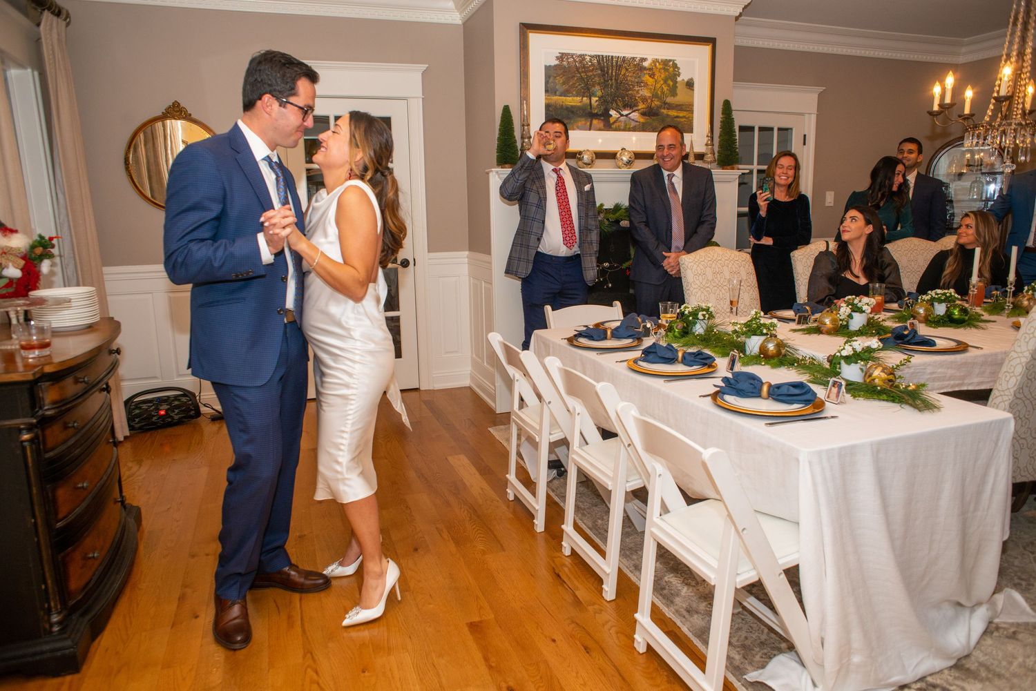 Couple shares a private moment near buffet table at indoor wedding reception.