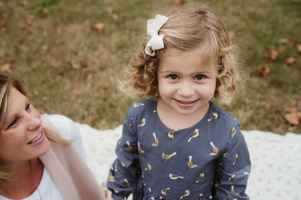 Close up portrait during an outdoor family photo session in a blue patterned dress.