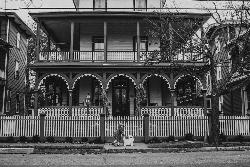 Elegant Victorian mansion with ornate balconies and detailed white trim against a cloudy sky.