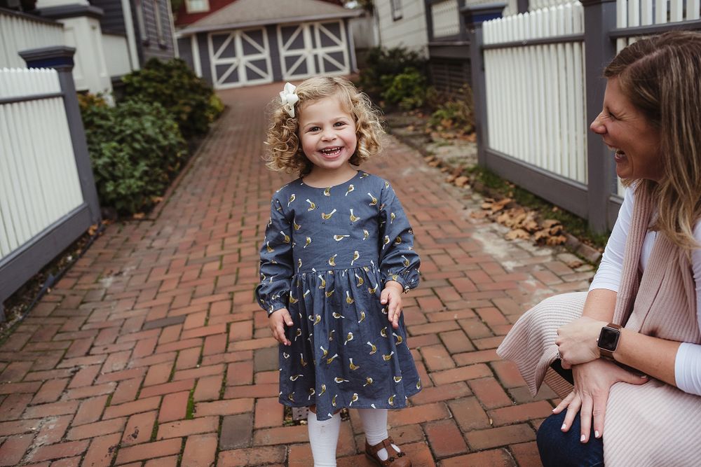 A joyful scene on a brick pathway with casual family interaction.