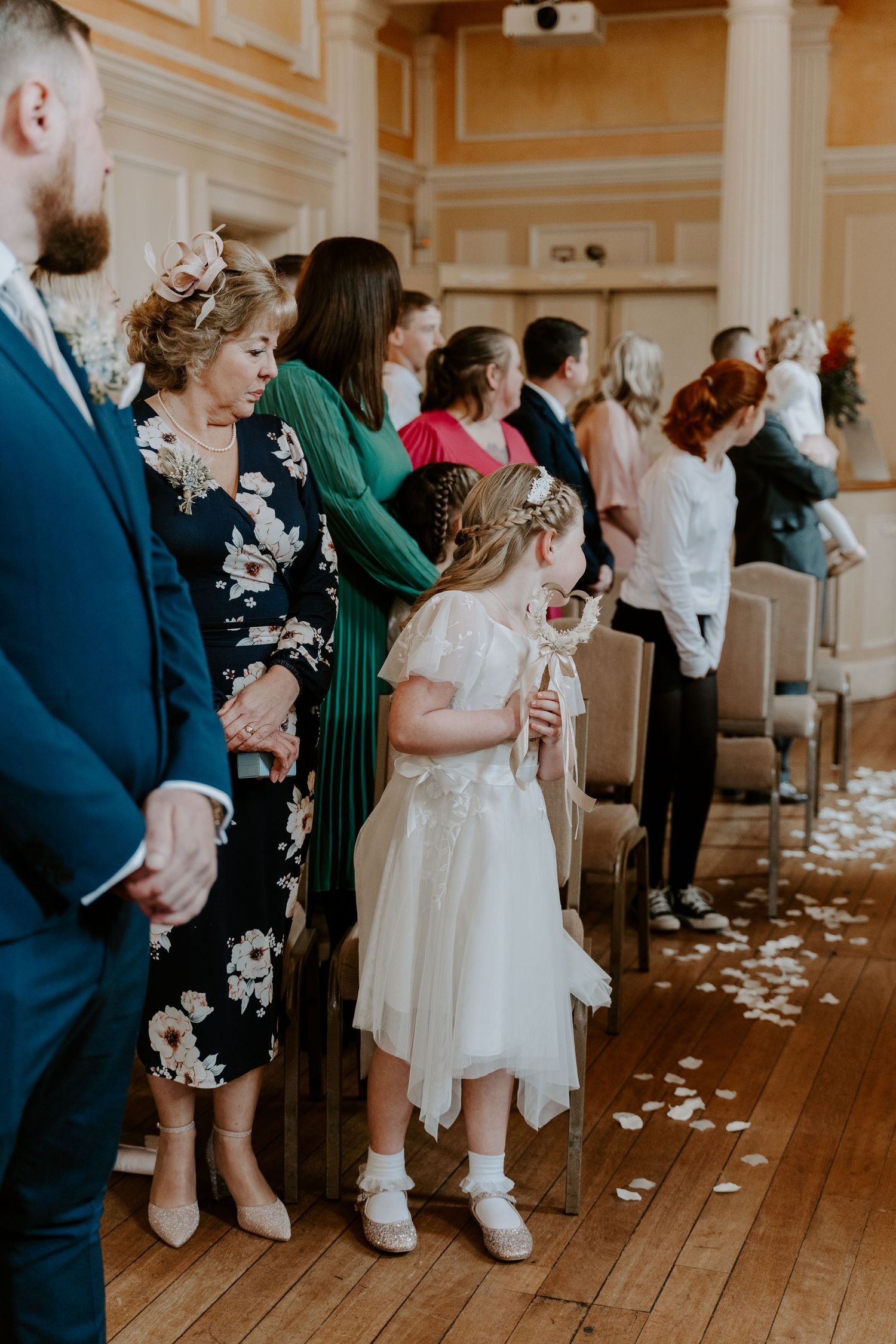 a flower girl looking back down the aisle waiting for the bride.