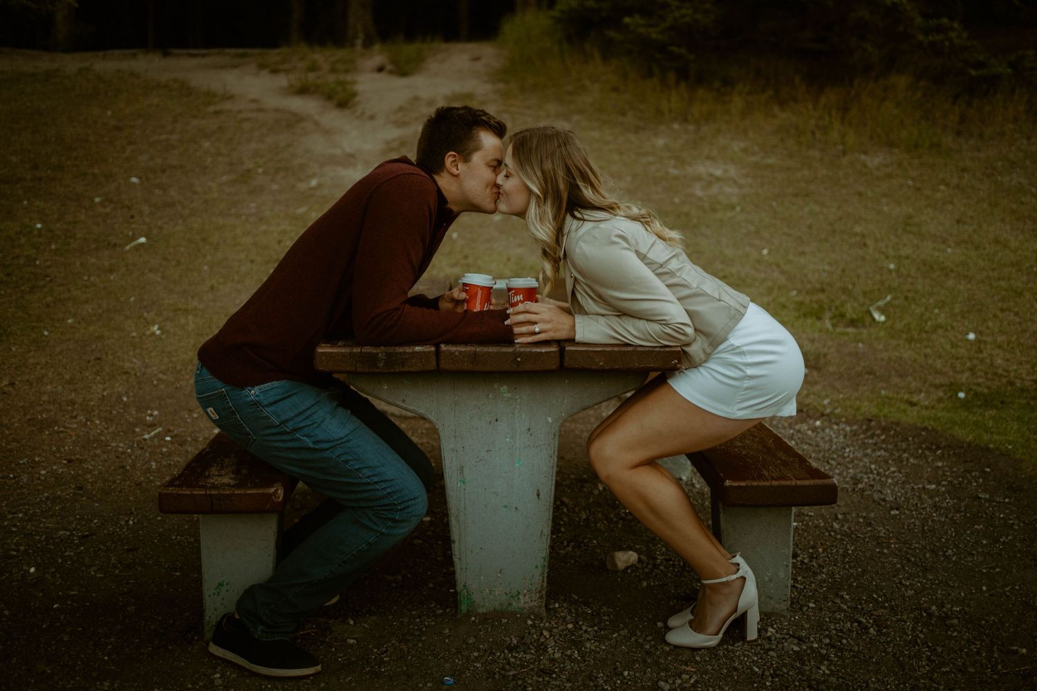 Romantic scene at rustic picnic table in evening light in Banff, Alberta for an engagement session.