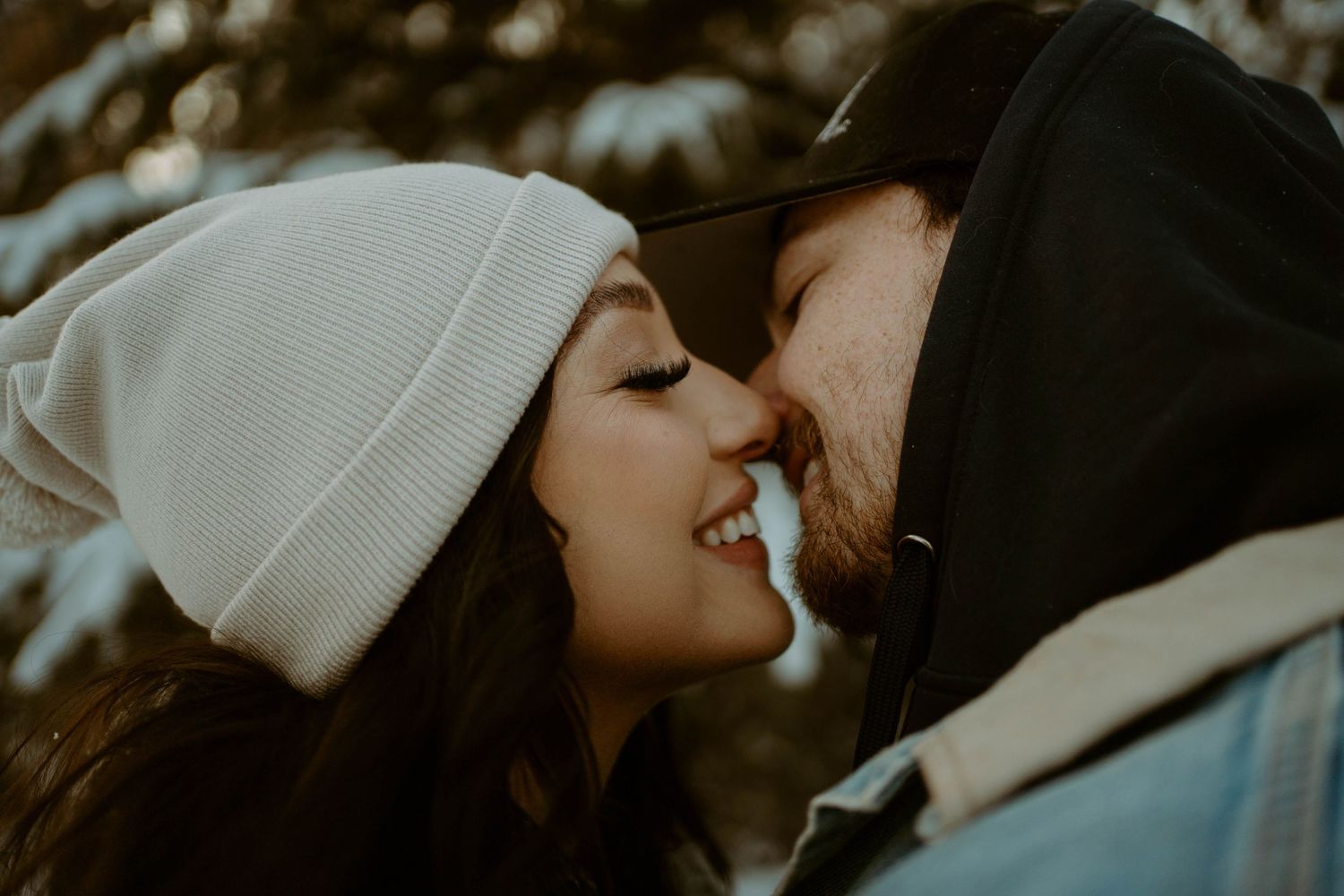 Close-up intimate moment between couple wearing winter beanies.