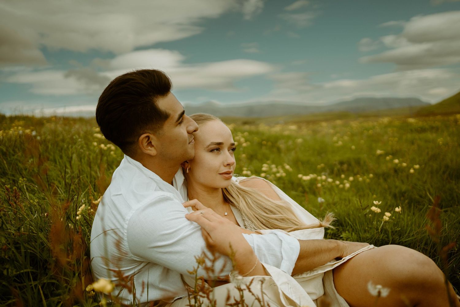 A tender moment shared in a summer meadow filled with wildflowers in Iceland.