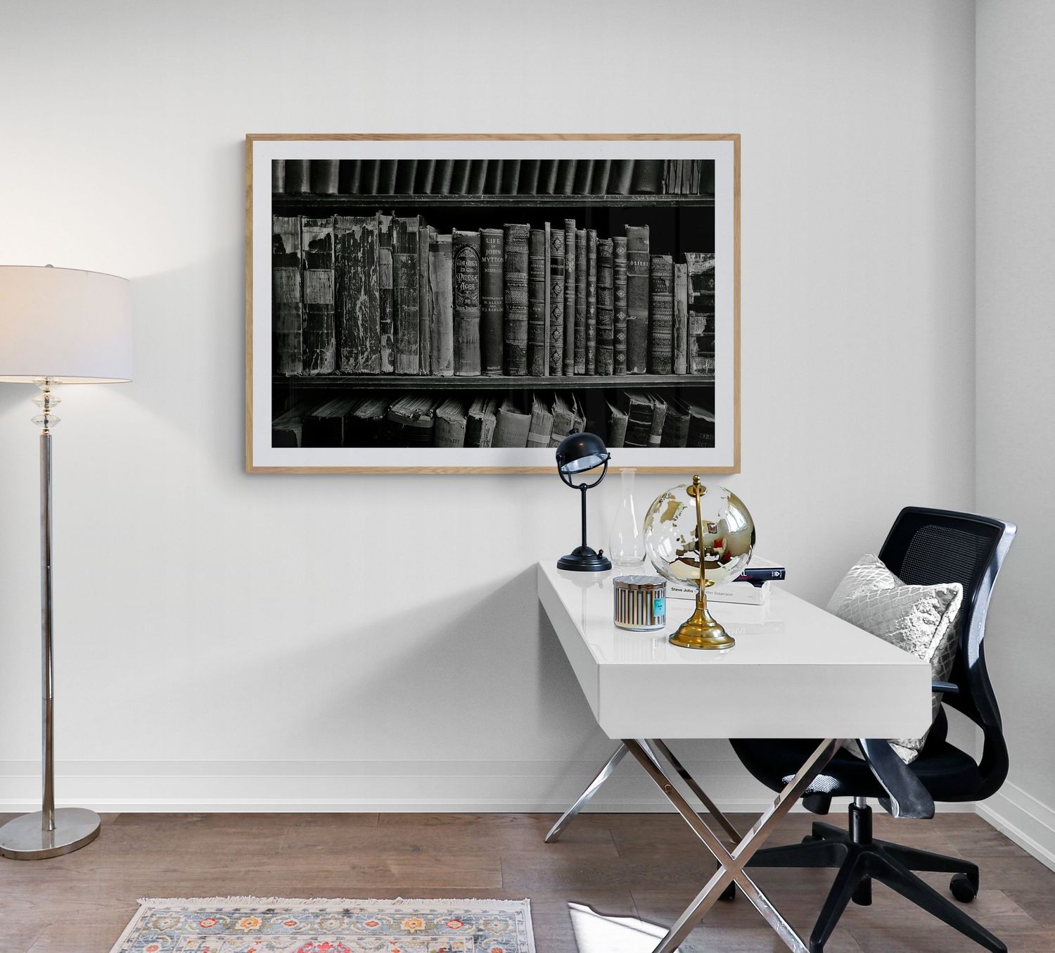 Vintage library photograph displayed above white desk with classic office accessories.
