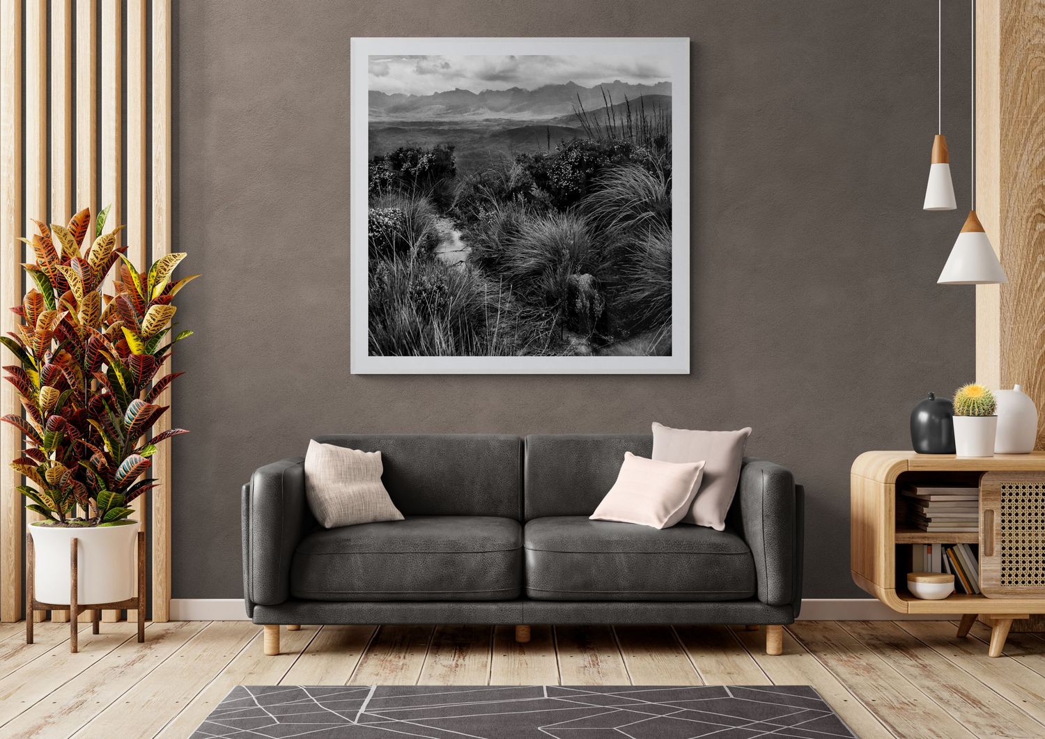 Modern living room with gray sofa, monochrome artwork, and decorative indoor plant.