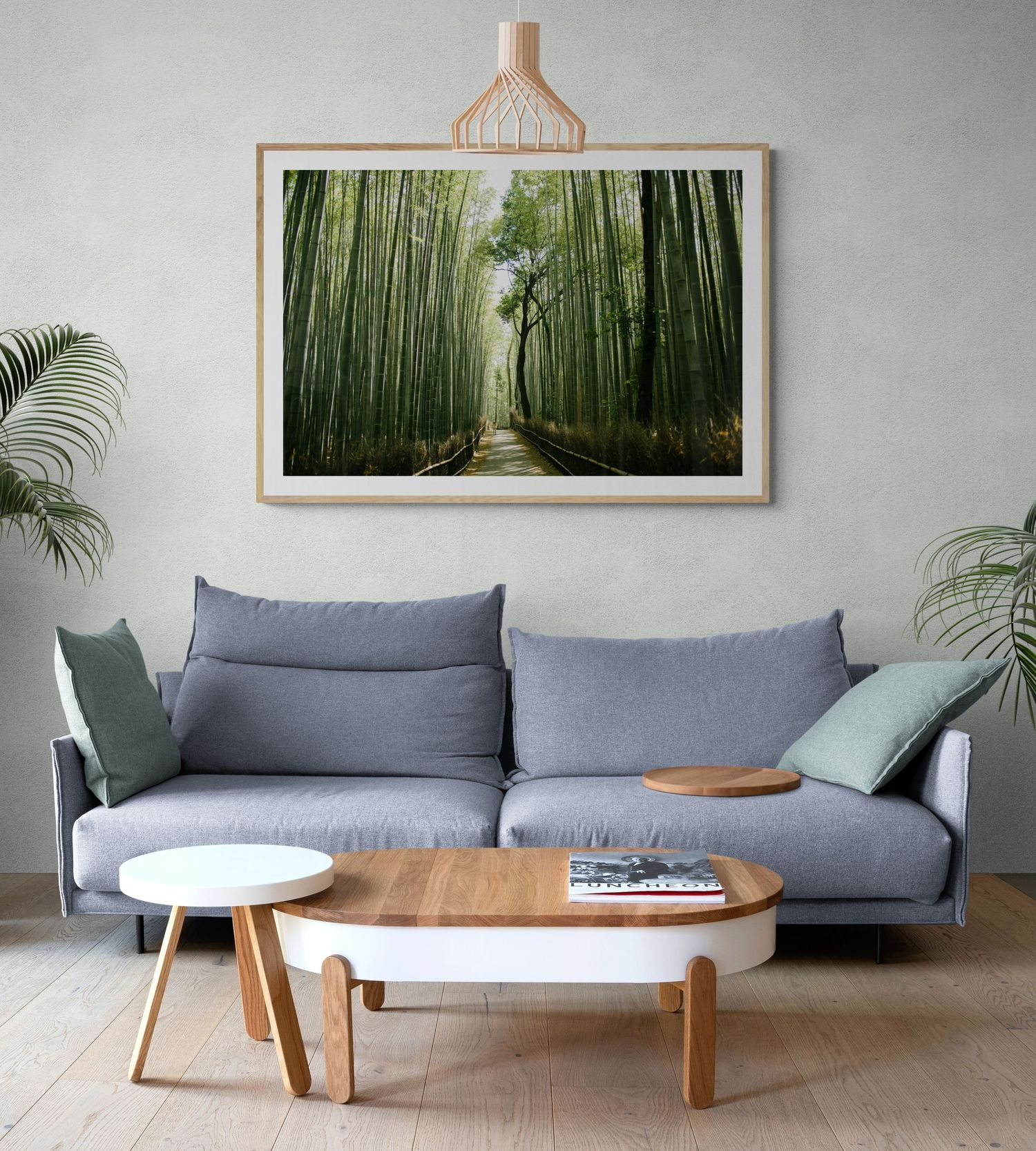 Modern living room interior with gray sofa and large framed bamboo forest artwork on the wall.