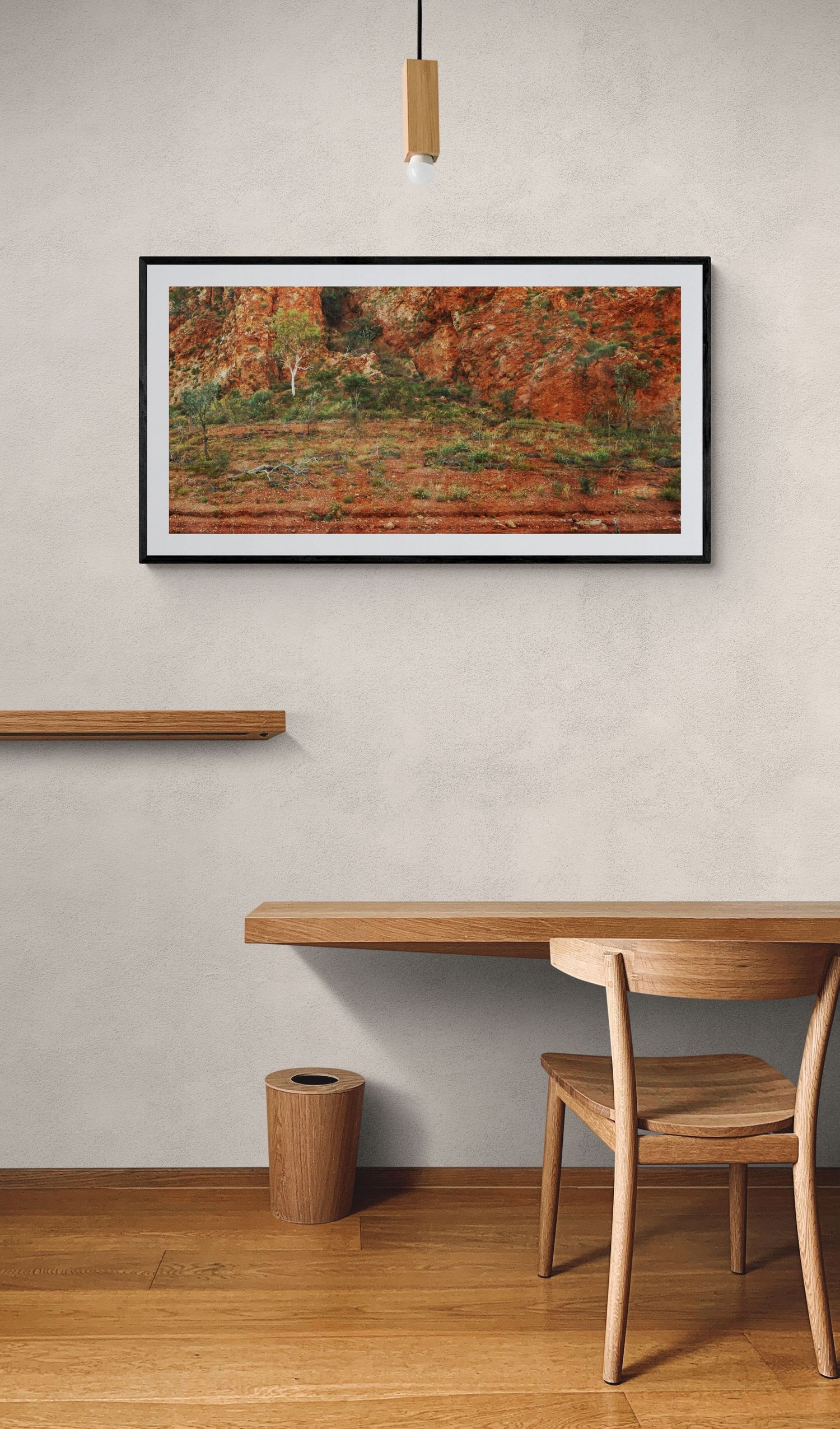 Abstract landscape art in warm autumn colors displayed above wooden dining furniture.