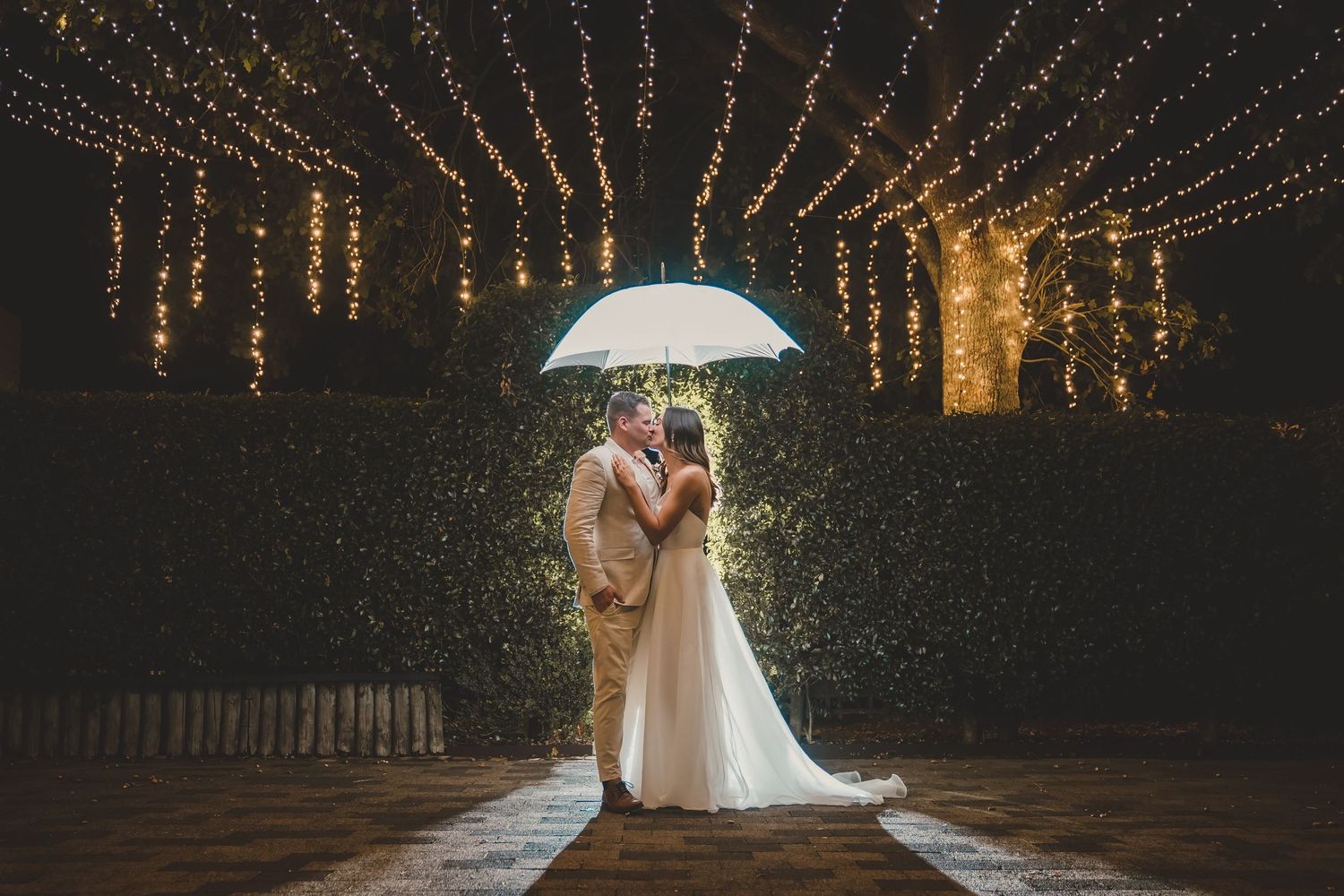 Allely Estate Wedding Couple umbrella shot with flash and fairy lights night shot of bride and groom