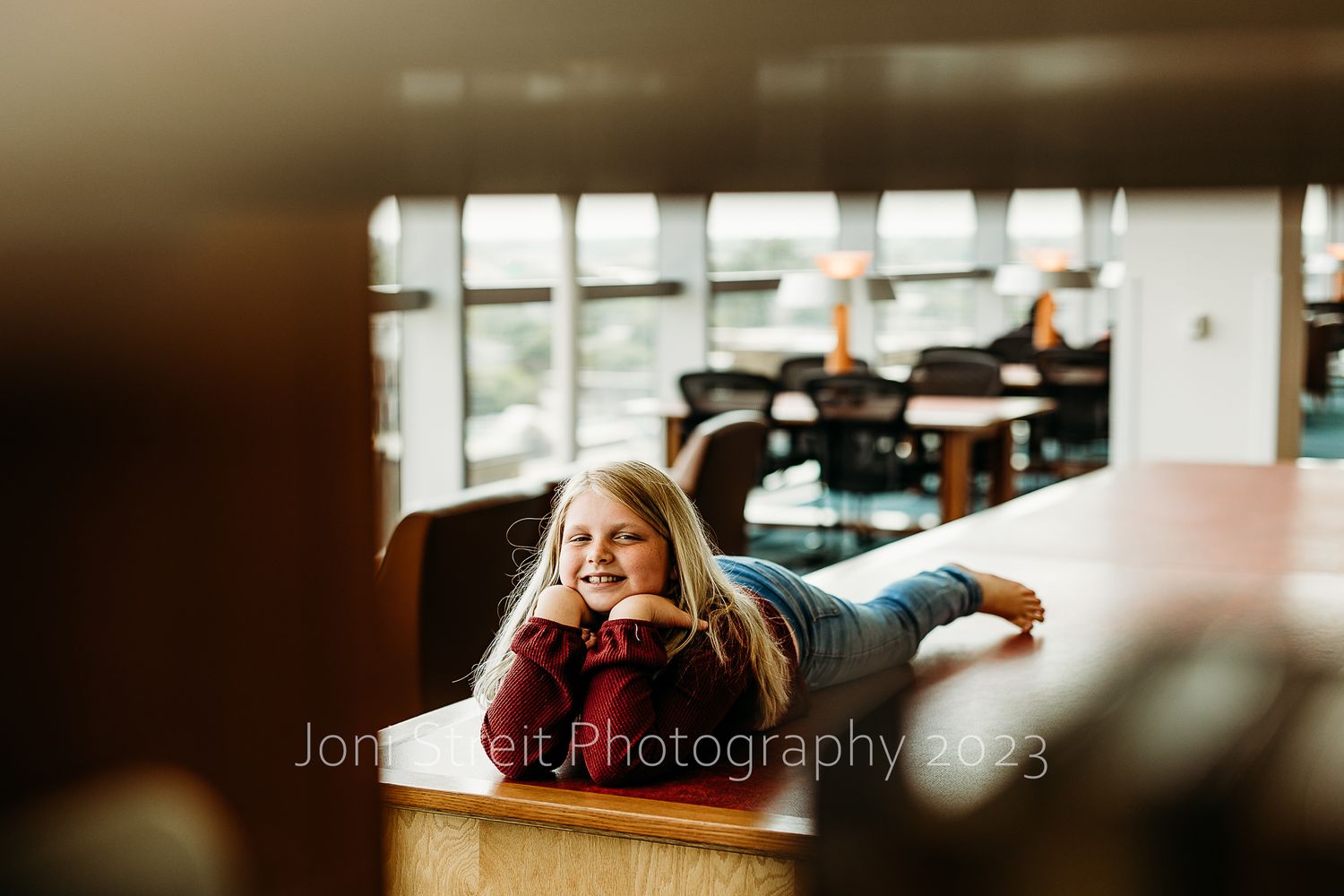 Cozy reading area in library with soft natural lighting filtering through windows.