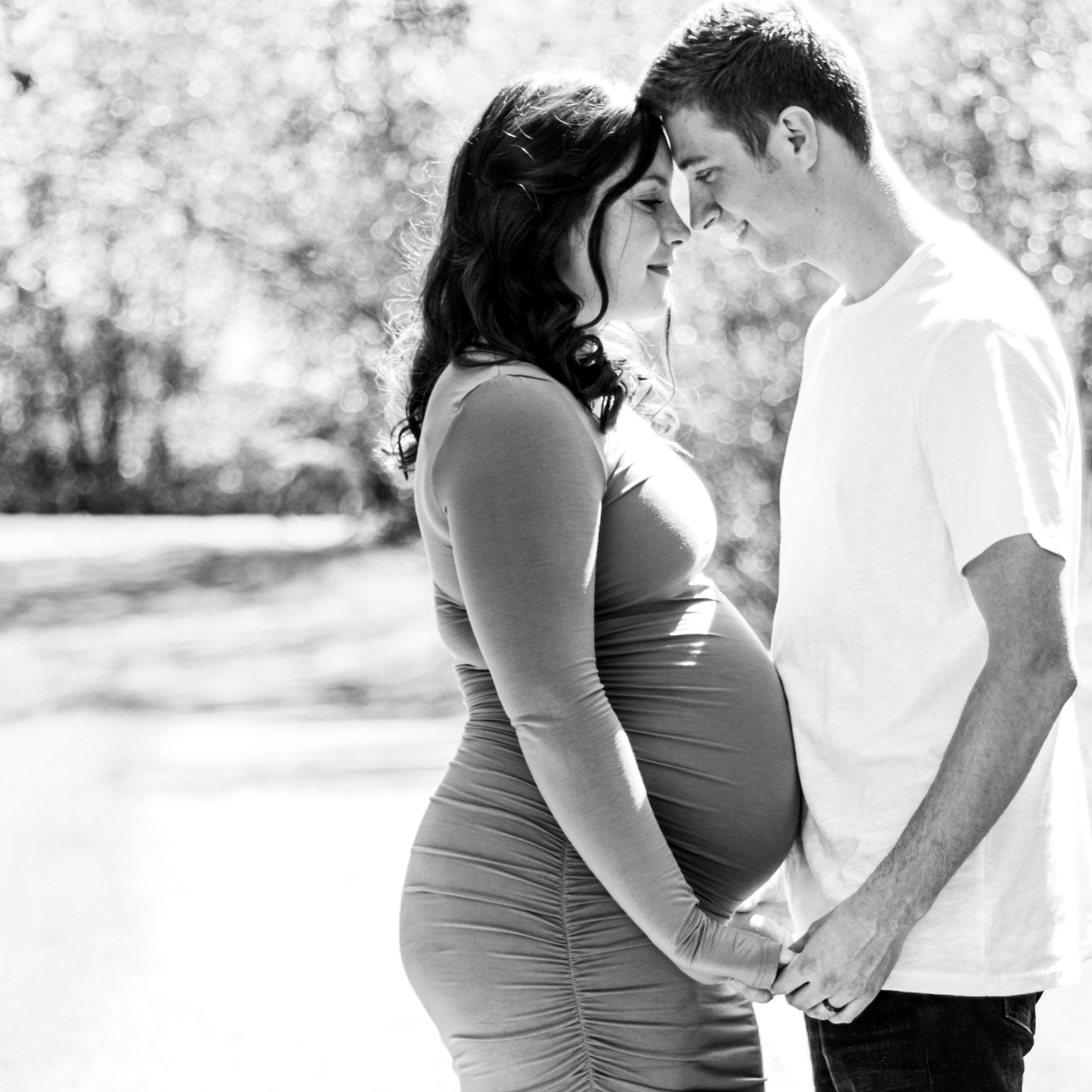 Intimate black and white photo of an expecting couple sharing a close moment together.