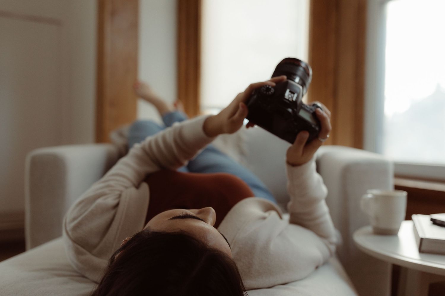 Virginia See Wedding Photographer lays on a couch looking relaxed at the back of her camera