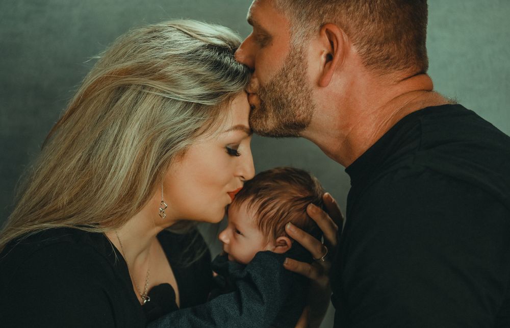 A romantic photo series showing a couple in black clothing against a moody green backdrop.